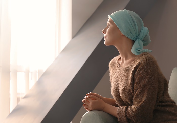 Fotografía de una mujer con cáncer mirando a lo lejos. 