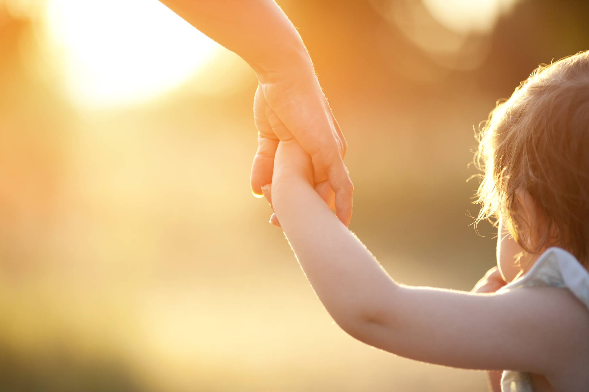 Niña pequeña cogida de la mano de su madre/padre