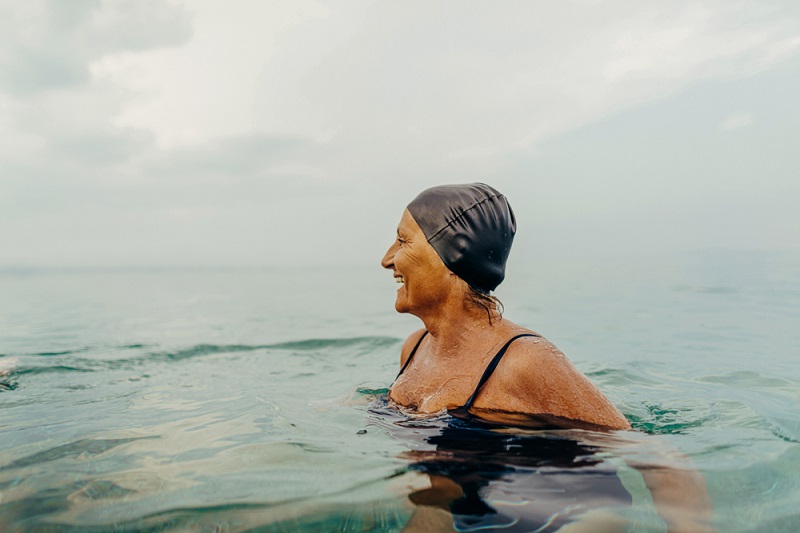 Mujer adulta mayor con gorro de baño en el mar