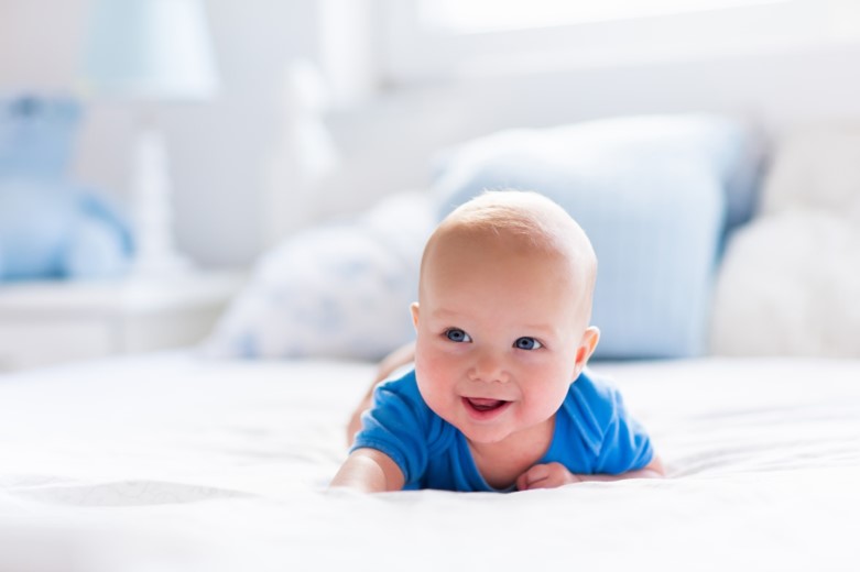  Adorable baby boy in white sunny bedroom